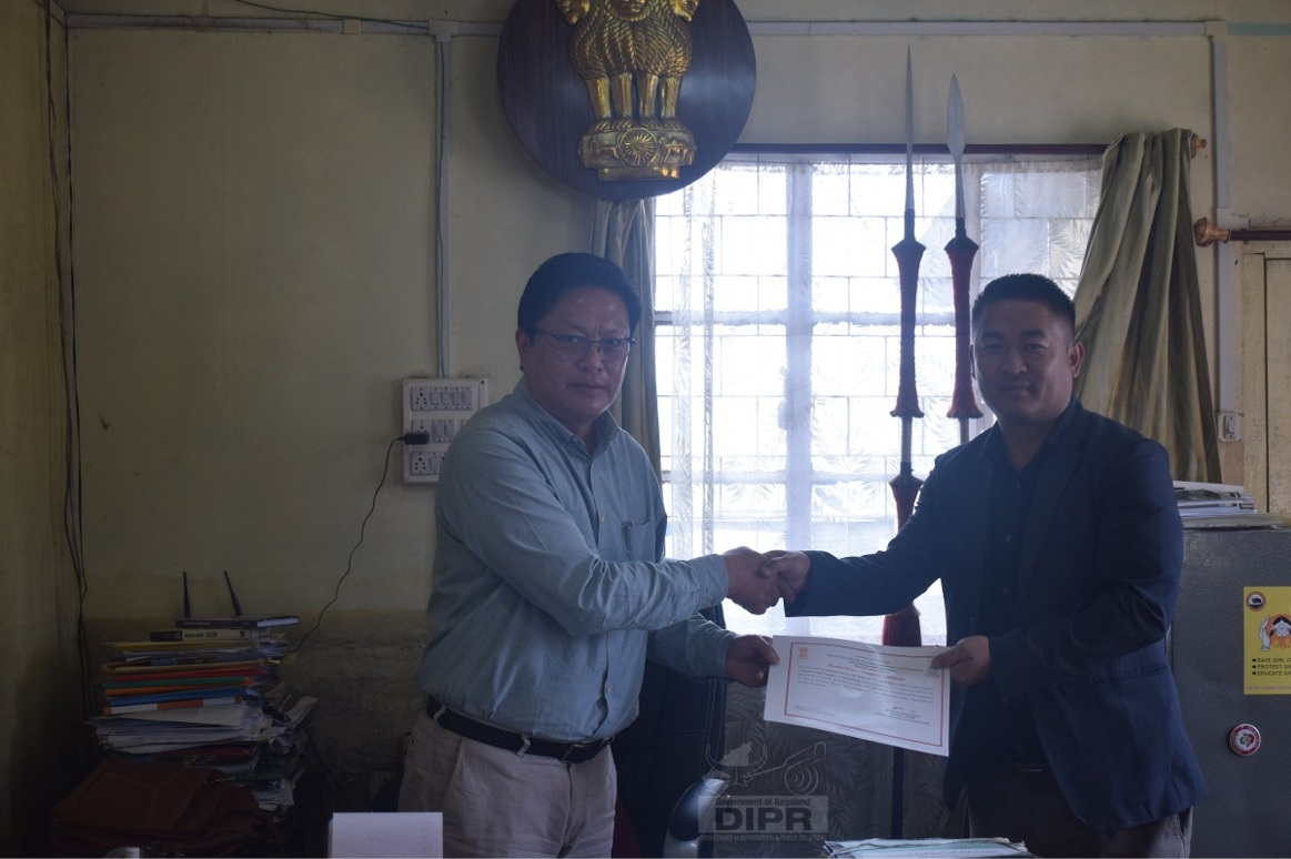 DC MOKOKCHUNG PRESENTING CERTIFICATE TO DISTRICT GREEN CHAMPION CERTIFICATE TO MOKOKCHUNG COLLEGE OF TEACHER EDUCATION